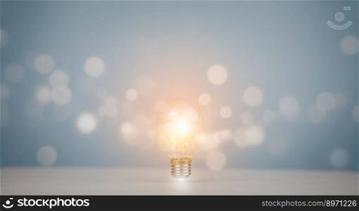 Thinking and creative concept,Light bulb with line bokeh on the wooden table,  light bulb style bokeh vintage dark background, Concept The idea of reading books, knowledge, and searching for new idea.