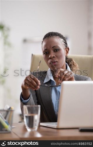 Thinking businesswoman in suit sitting at workplace and working hard with laptop