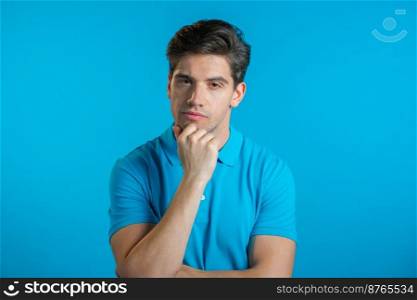 Thinking man looking up and around on blue background. Pensive face expressions. Handsome male model. Thinking man looking up and around on blue background. Pensive face expressions. Handsome male model.