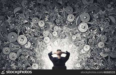 Thinking mechanisms. Thoughtful businessman with gear mechanisms above his head