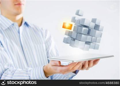 Thinking outside the box as concept. Businessman holding tablet and cube as symbol of problem solving