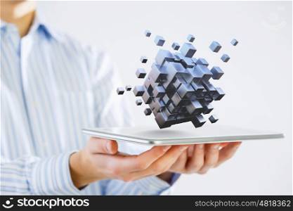 Thinking outside the box as concept. Businessman holding tablet and cube as symbol of problem solving