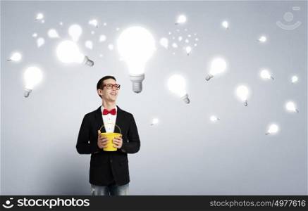Thinking outside the box. Young funny guy wearing jacket splashing bulbs from yellow bucket