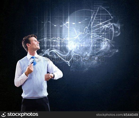 Thinking over the idea. Young businessman smoking pipe with diagrams and graphs at background