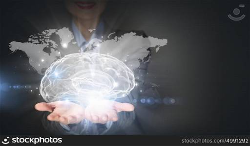 Thinking wide. Close up of businesswoman holding brain concept in palms
