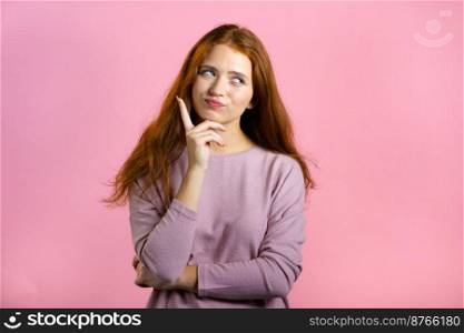 Thinking woman looking up and around on pink background. Happy smiling face expressions. Pretty model with attractive appearance.. Thinking woman looking up and around on pink background. Happy smiling face expressions. Pretty model with attractive appearance