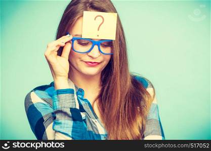 Thinking woman with big nerdy eyeglasses and question mark on forehead. Creating new idea, studying and education concept.. Thinking woman with big eyeglasses and light bulb