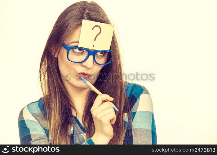 Thinking woman with big nerdy eyeglasses and question mark on forehead, on beige bright. Creating new idea, studying and education concept.. Thinking woman with big eyeglasses and light bulb