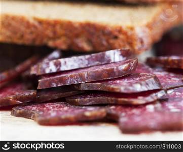 Thinly sliced at home meat sausage with black bread, Slavic sandwiches. Slavic sandwiches