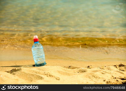 thirst and bevarage. closeup of plastic bottle of water drink on a sandy summer beach. vacation fitness