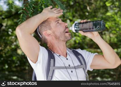 thirsty male hiker drinking water