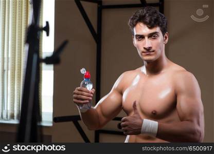 Thirsty man drinking water in sports gym