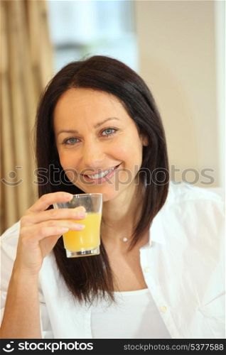 thirty-ish brunette drinking orange juice