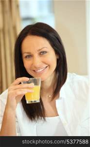 thirty-ish brunette drinking orange juice