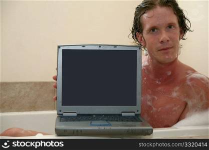 Thirty something man in bubble bath with laptop. Screen facing camera.