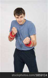 thirty young athletic man does physical exercises. Athlete fulfills punches with the weighting