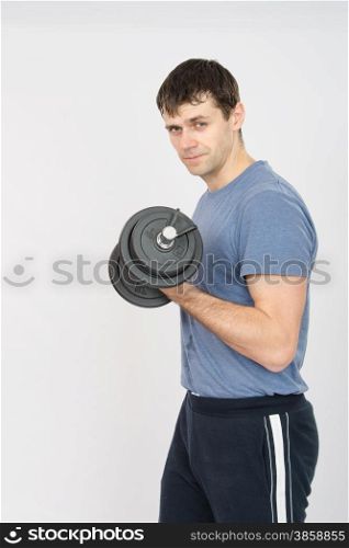 thirty young athletic man does physical exercises. Athlete shakes his left hand