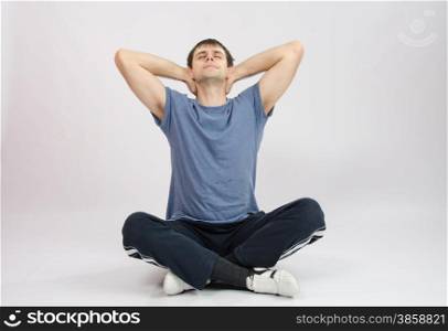 thirty young athletic man does physical exercises. Athlete stretches the muscles of back