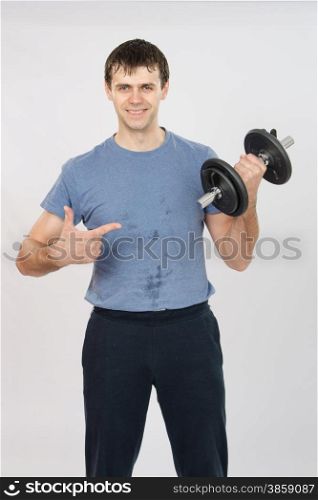 thirty young athletic man does physical exercises. athlete with a positive indicates dumbbell