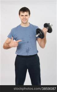 thirty young athletic man does physical exercises. athlete with a positive indicates dumbbell