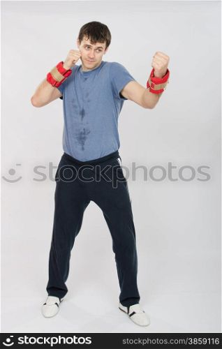 thirty young athletic man does physical exercises. Growth portrait of boxer worked blows with weighting