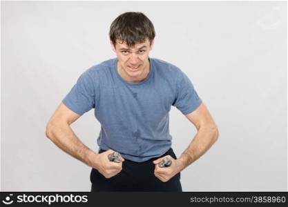 thirty young athletic man does physical exercises. Portrait of hard athlete with expander