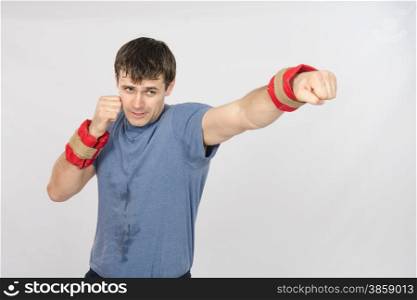 thirty young athletic man does physical exercises. The athlete has his left hand with the weighting agent