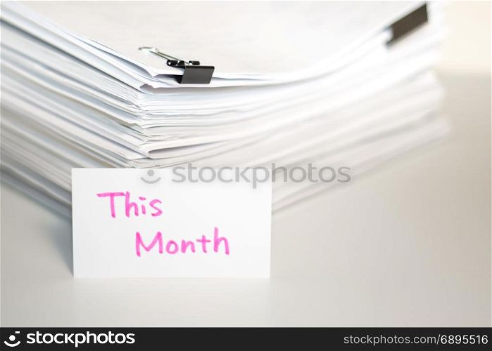 This Month; Stack of Documents on white desk and Background.