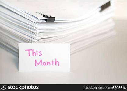 This Month; Stack of Documents on white desk and Background.