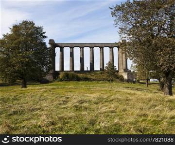This partially completed replica of the Parthenon is known as the Scottish National Monument. Located on Calton Hill near the center of Edinburgh in Scotland, this structure is unfinished due to lack of funds.