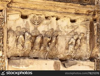 This wall relief on the Arch of Titus reveals Roman soldiers carrying spoils from the destruction of the Temple of Jerusalem in 70 A.D including the golden Temple Menorah, the Table of the Shewbread and the silver trumpets which called Jews to the festivals. The Romans are in triumphal procession wearing laurel crowns and the ones carrying the Menorah have pillows on their shoulders.