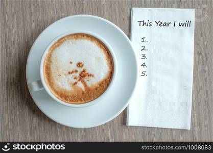 THIS YEAR I WILL word with hot cappuccino coffee cup on table background at the morning. New Year New Start, Resolution, Solution, Strategy and Mission concept