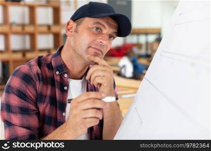 thoughtful architect bworking in modern studio with blueprint