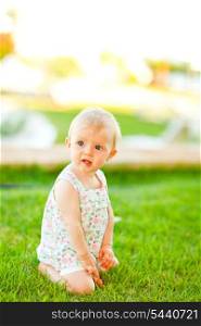 Thoughtful baby playing on grass&#xA;
