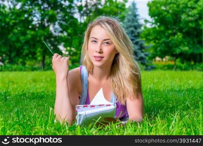 thoughtful beautiful girl with a notebook resting in the park