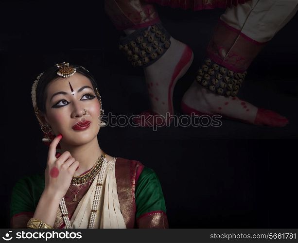 Thoughtful Bharatanatyam dancer over black background