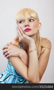 thoughtful blond girl on light background