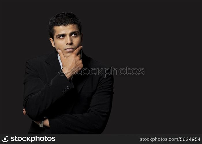 Thoughtful business man over black background