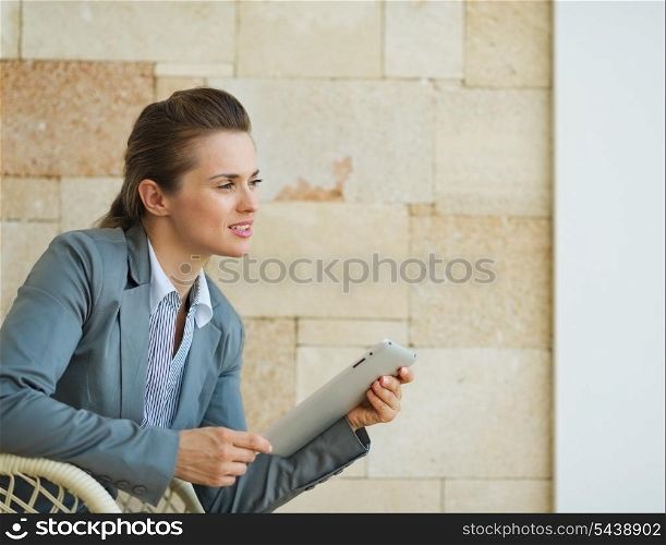 Thoughtful business woman holding tablet PC and looking on copy space