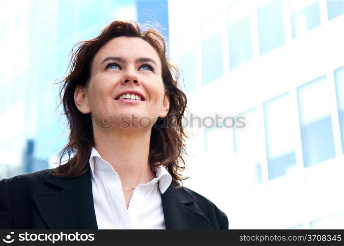 Thoughtful business woman looking up and smiling
