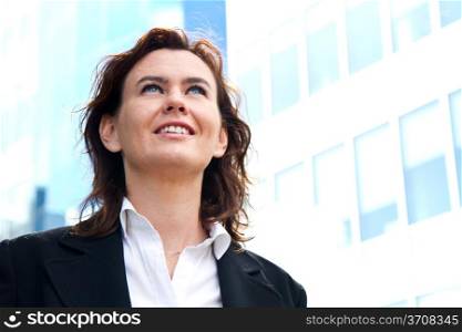 Thoughtful business woman looking up and smiling