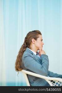 Thoughtful business woman sitting on terrace