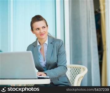 Thoughtful business woman working on laptop