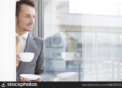 Thoughtful businessman having coffee in office