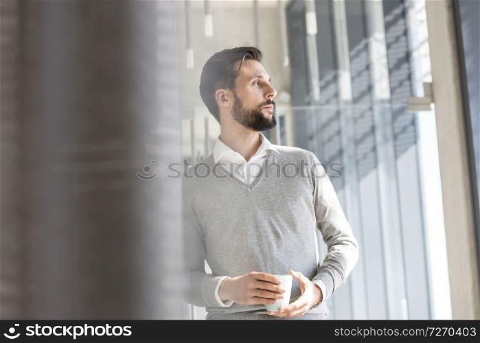 Thoughtful businessman having coffee in office