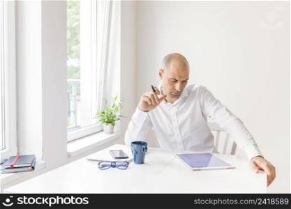 thoughtful businessman looking graphic digital tablet workplace