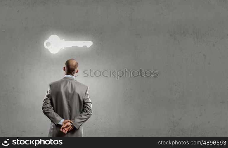 Thoughtful businessman. Rear view of businessman looking at key