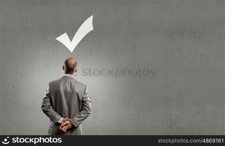Thoughtful businessman. Rear view of businessman looking at tick above head