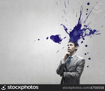 Thoughtful businessman with colorful splashes out of his head. Man with colored head