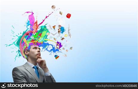Thoughtful businessman with colorful splashes out of his head. Man with colored head